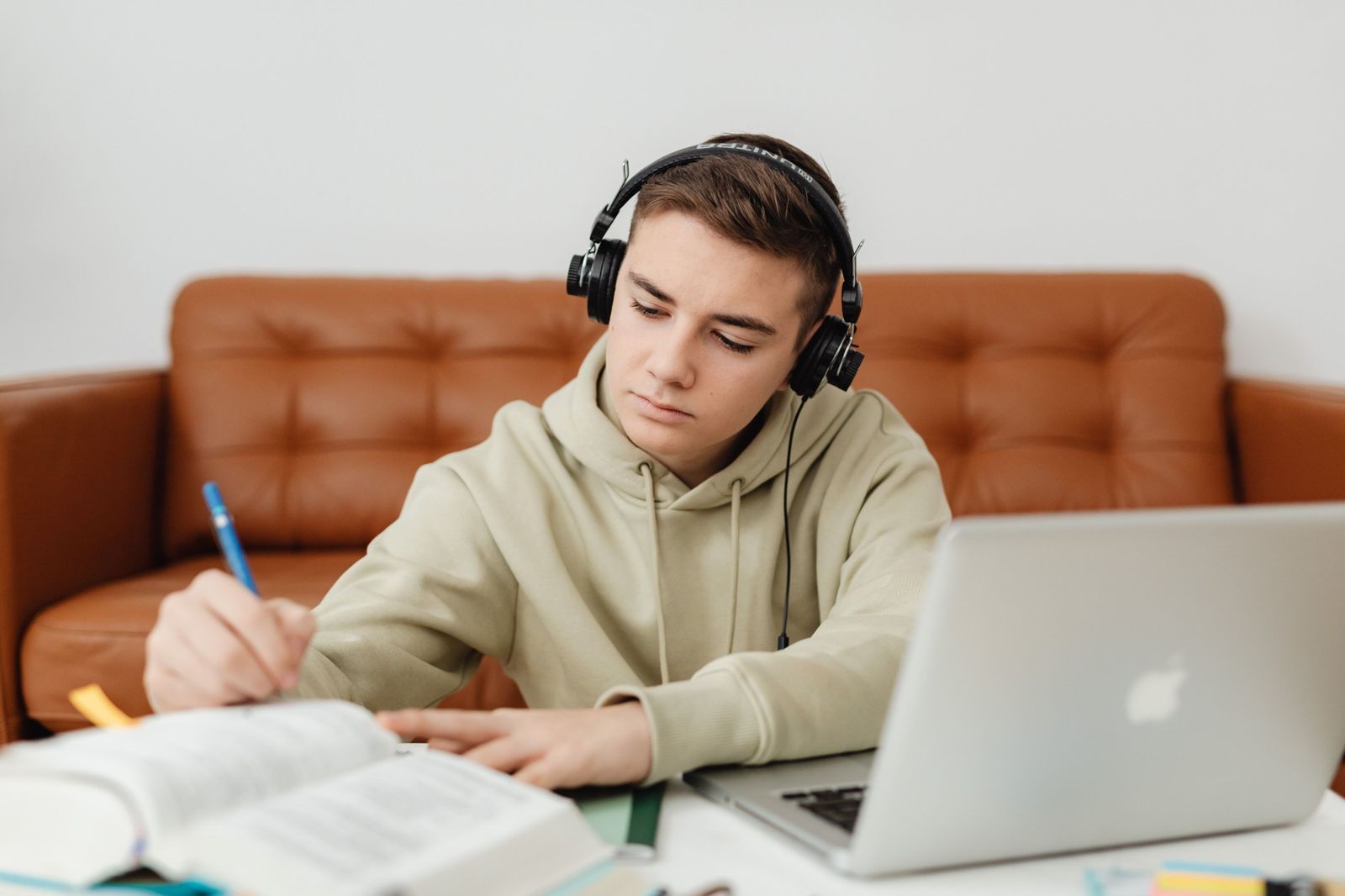Un ragazzo con le cuffie studia al portatile